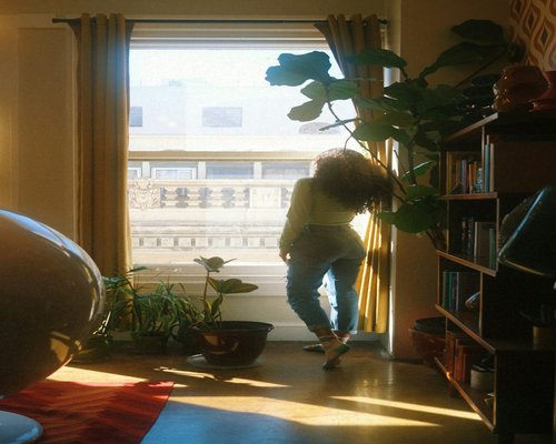 Person looking out of a window in an apartment taking a screen break